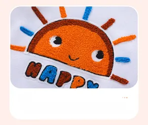 Close-up of towel-embroidered orange sun and colorful HAPPY text on white cotton sweatshirt