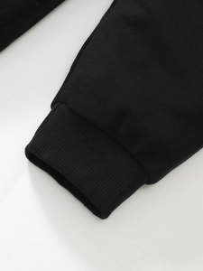 Detail of black cotton cargo pants showing elastic ribbed cuffs and high-quality knitting