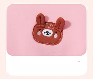 Detail of pink fleece sweatshirt featuring 3D brown bear embroidery and premium stitching