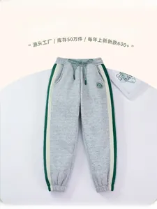 Detail of grey fleece-lined joggers with green drawstring and contrast side stripes