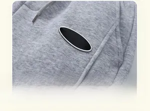 Macro detail of gray knitted fleece joggers with embroidered patch and fine fabric texture