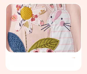 Detail of soft cotton girl's dress with cute bunny and floral applique embroidery