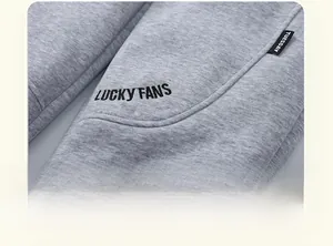 Detail of gray fleece kids pants featuring side embroidery and curved stitching craftsmanship