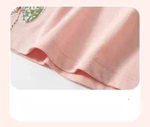 Detail of pink polka dot cotton dress featuring leaf embroidery and durable double stitching