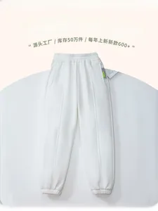 Detail of white fleece-lined kids jogger pants with elastic cuff and side woven label
