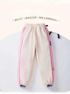 Detail of children's warm cream joggers with pink side stripes and blue ankle print