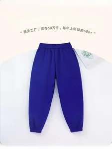 Detail of navy blue kids joggers with STRANDED embossed text and elastic ribbed cuffs