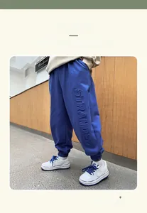 Detail of blue toddler joggers with embossed STRANDED lettering and ribbed cuffs