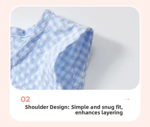 Vue détaillée du tissu vichy bleu et de la coupe à l'épaule sur la robe pour petite fille
