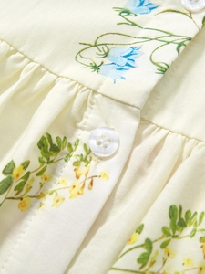 Girl cotton floral dress with ruffled collar and button detail on cream fabric