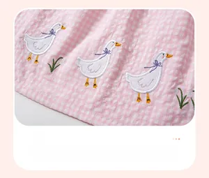 Détail d'une robe en seersucker vichy rose avec broderie appliquée de canard blanc