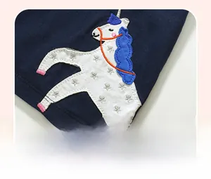 Detailansicht der Einhorn-Applikation mit Sternenmuster auf dunkelblauem Polo-Shirt