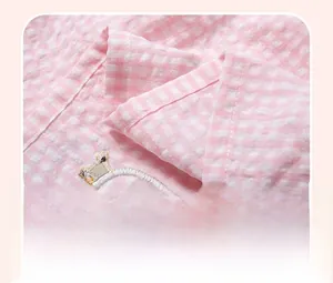 Détail de robe en coton à carreaux roses montrant les coutures et la texture seersucker