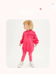 Detail of girls pink casual tracksuit featuring long sleeve sweatshirt with large bow decoration