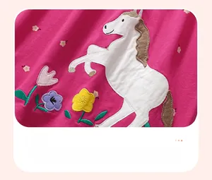 Detalle de bordado aplicado de unicornio blanco y flores en vestido de algodón rosa