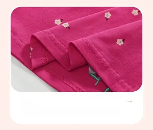 Detalle del dobladillo en un vestido de algodón rosa para niñas con bordado floral