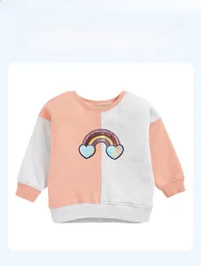 Detail of children's ribbed neckline and sequined rainbow heart patch on pink sweatshirt