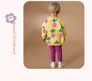 Detail view of yellow long-sleeve sweatshirt with carrot print and purple ribbed leggings