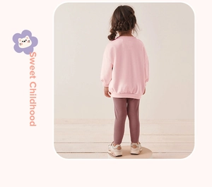 Rückansicht von Mädchen in rosa Sweatshirt und lila Leggings auf Holzboden-Hintergrund