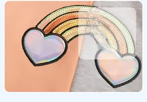 Detailed close-up of rainbow sequin embroidery and laser-heart patches on cotton jacket