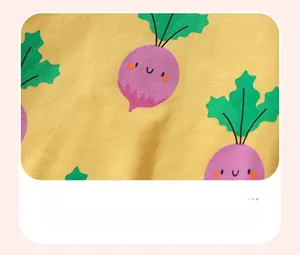 Close-up of soft yellow cotton fabric with cute purple cartoon carrot prints