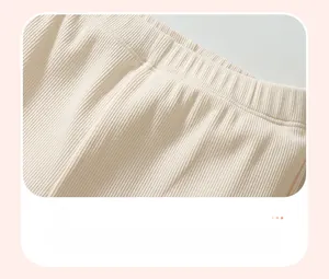 Detailed macro view of the elastic ribbed waistband on beige cotton toddler trousers