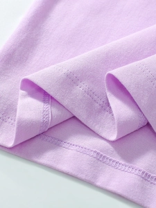 Gros plan d'un t-shirt enfant violet en coton montrant les détails de couture à double aiguille