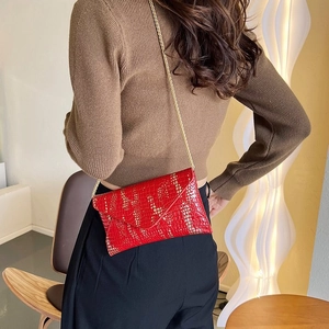Elegante bolso sobre rojo con textura de cocodrilo, bolso bandolera con cadena dorada