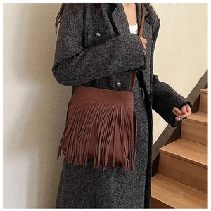 Détail du sac bandoulière en similicuir marron foncé avec franges sur un mannequin