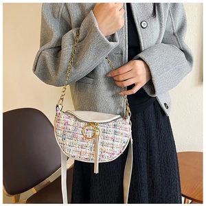 Detail of tweed crossbody bag featuring a golden chain and circular metal handle decoration