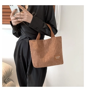Detalle de un bolso tote de pana marrón con un parche de cuero con texto Fashion Bags