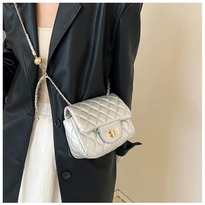 Detail der silbernen Stepptasche mit goldener Kugelkette und Drehverschluss-Verschluss