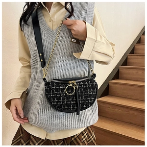 Detail of tweed saddle bag showing black and white checkered texture and gold chain strap