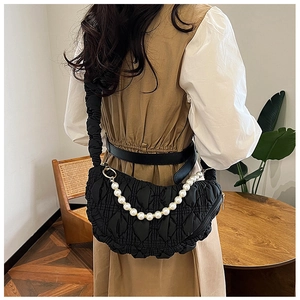 Detail view of black pleated crescent shoulder bag with large pearl chain and shoulder strap