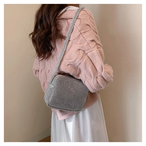 Close-up of sparkling silver rhinestone crossbody bag on model with delicate chain strap