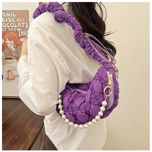 Detail of purple quilted cloud crescent bag with faux pearl chain and pleated strap