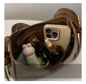 Interior view showing capacity of dark brown vintage underarm bag with zipper pocket