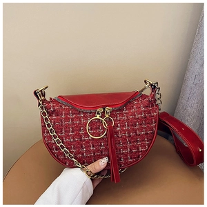 Close-up of red tweed dumpling bag showing chain strap and metallic zipper detail