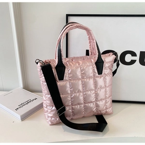 Detailed close-up of pink quilted puffer tote bag with black handles and shoulder strap