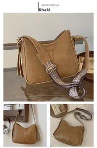 Detail of khaki PU leather bucket bag featuring a woven ethnic style wide strap and gold hardware