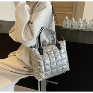 Vue détaillée du sac seau argenté matelassé avec texture à carreaux et poignée noire