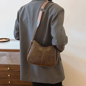 Vintage dark brown crossbody bucket bag with geometric woven wide shoulder strap on model
