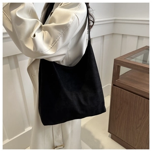 Detail of the large capacity black suede crossbody bag showing the soft texture and silhouette