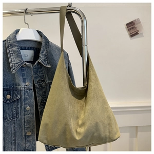 Detail of olive green suede tote bag showing soft matte texture and wide shoulder strap