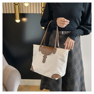 Large canvas tote bag with brown leather trim shown on model for daily commuting