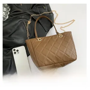 Vue détaillée du sac cabas matelassé marron avec chaîne dorée et accessoires de mode
