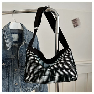 Detailansicht einer schwarzen Hobo-Tasche mit glänzenden Strasssteinen und breitem Gurt