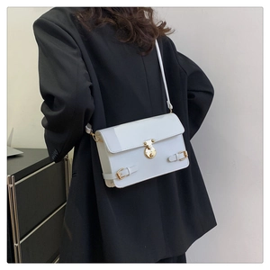 Model view of a white rectangular crossbody bag with a gold lock and minimalist retro style