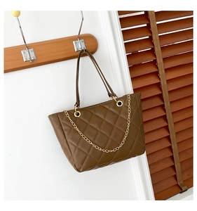 Détail du sac cabas matelassé marron foncé avec chaîne dorée et finition similicuir