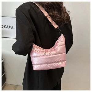 Vista posteriore della modella con borsa a tracolla trapuntata rosa su un blazer nero elegante